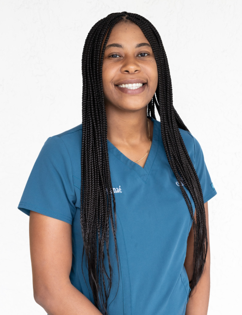 Smiling female healthcare professional in blue scrubs against white background