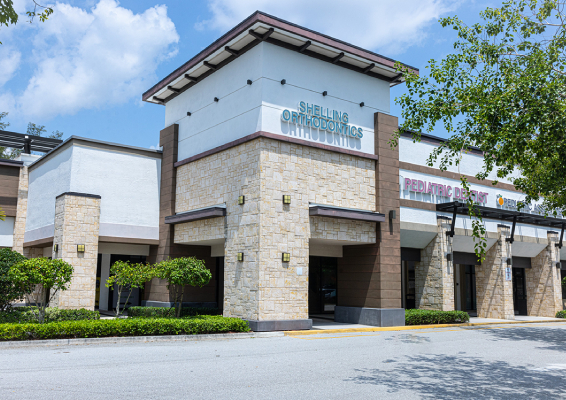 Modern orthodontic office building with stone facade and entrance signage in Boca Raton.